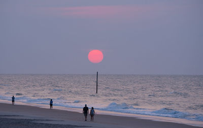 People walking at sunrise on topsail island