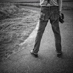 Low section of man standing on field