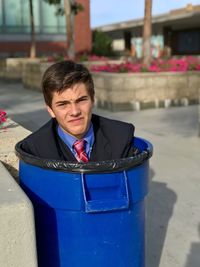 Portrait of young man in garbage bin