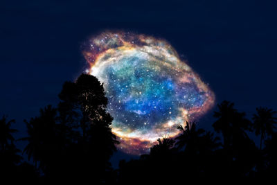 Low angle view of silhouette trees against sky at night