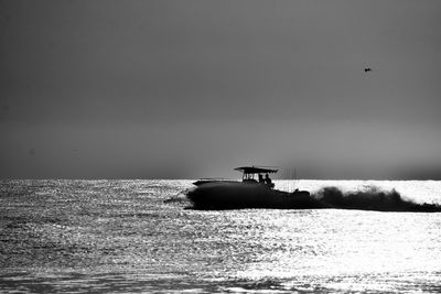 Boat sailing in sea against clear sky