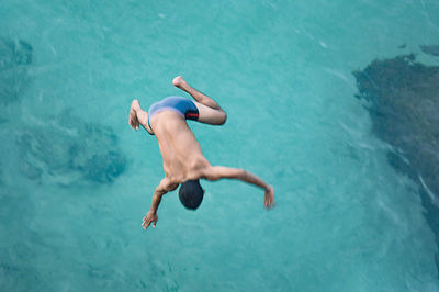 High angle view of man jumping in swimming pool