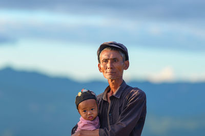 Portrait of father and son against sky