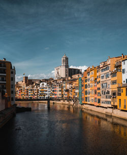 River amidst buildings in city against sky