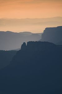 Scenic view of silhouette mountains against sky at sunset