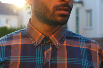 Midsection of man in button down shirt standing against building