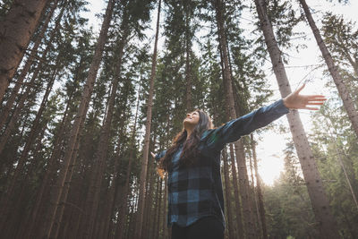 Rear view of woman standing in forest