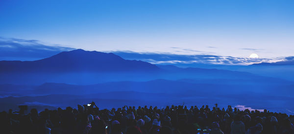 Group of people on mountain against sky