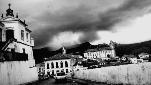 Houses in town against cloudy sky