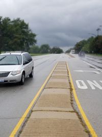 Car on road against cloudy sky