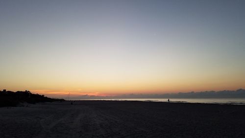 Scenic view of silhouette field against clear sky during sunset