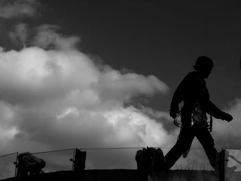 Low angle view of silhouette man against sky