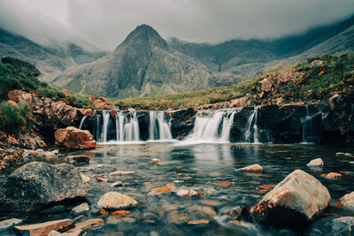 Scenic view of waterfall against mountain