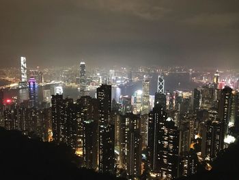 Illuminated cityscape against sky at night
