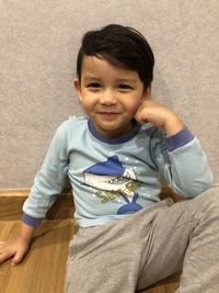 Portrait of smiling boy sitting on floor