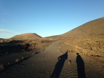 Shadow of people on desert against clear sky, lanzarote, volcano,   timanfaya