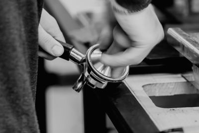 Cropped hands preparing coffee in cafe