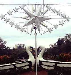 Digital composite image of chain swing ride against sky