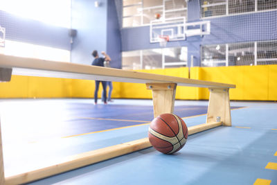 Basketball by bench at court