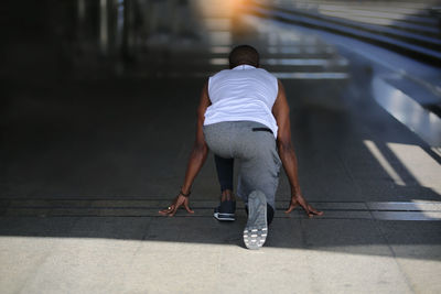 Rear view of man walking on footpath in city
