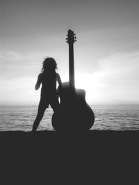 Silhouette of woman on beach at sunset