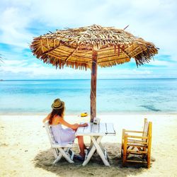 Woman sitting on chair at beach