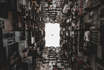 Directly below shot of buildings in city against sky