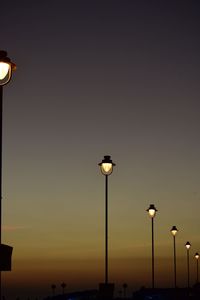 Low angle view of illuminated street light against sky