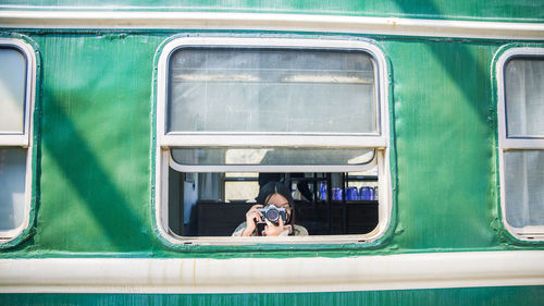 Woman photographing while traveling in train