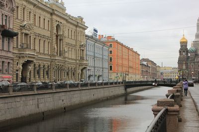 Bridge over river against buildings in city