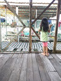 Rear view of woman standing on railing