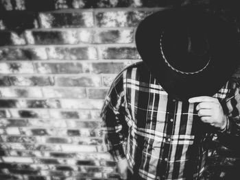 Full length portrait of person standing against wall