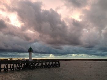 Lighthouse by sea against sky