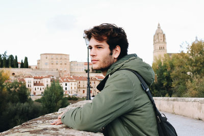 Portrait of young man standing against clear sky