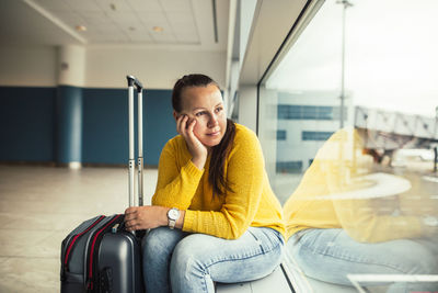 Full length of man sitting at airport