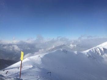 Scenic view of snowcapped mountains against blue sky