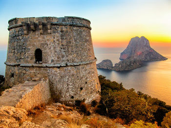 Old ruins by sea against sky