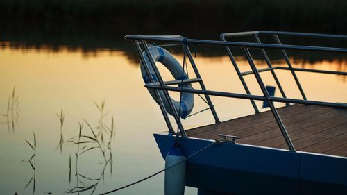 Close-up of boat moored at lake