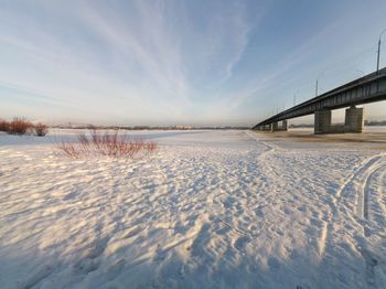 Bridge over lake against sky during winter