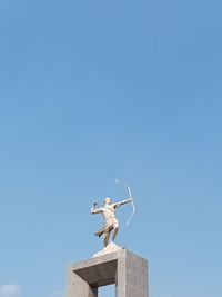 Low angle view of statue against clear blue sky