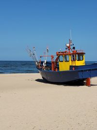 Boats in sea against clear blue sky