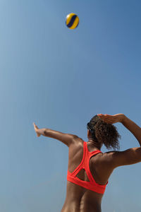 Woman with afro hair playing beach volleyball