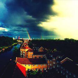 Illuminated cityscape against cloudy sky