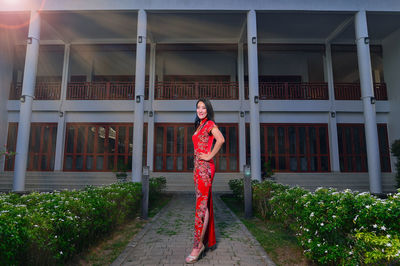 Portrait of woman standing by red structure