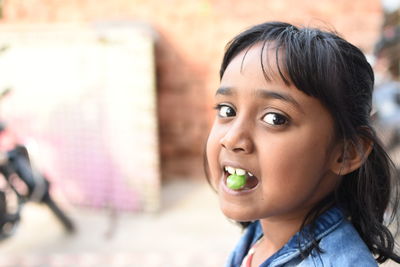 Close-up portrait of girl eating candy