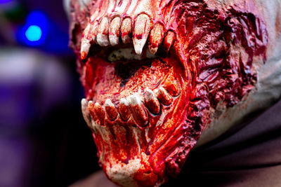 The bared fangs of a vampire zombie covered in blood 