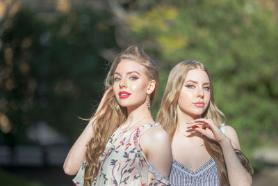 Portrait of beautiful friends standing in park