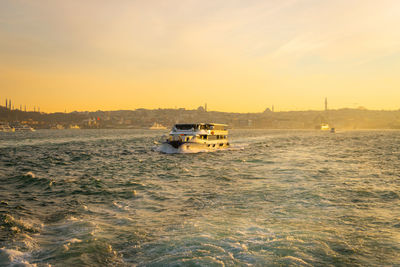 Boat sailing in sea against sky during sunset