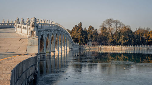 Arch bridge over river against sky