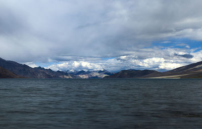 Scenic view of sea and mountains against sky